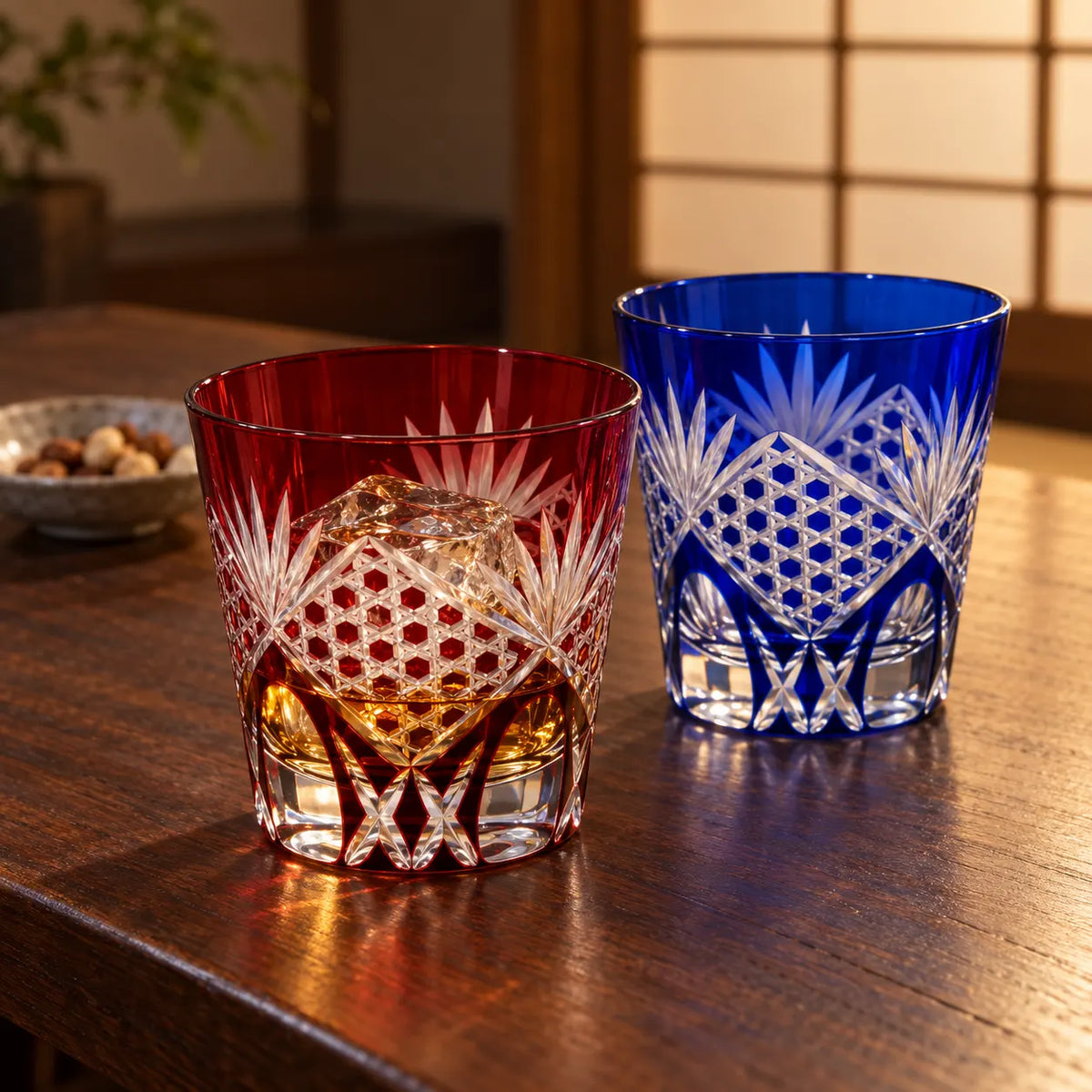 Red and blue Edo Kiriko Rokkaku Kagome tumblers on a walnut table, one with whisky and ice