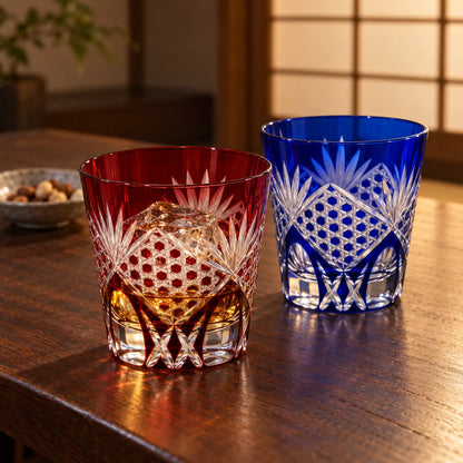 Red and blue Edo Kiriko Rokkaku Kagome tumblers on a walnut table, one with whisky and ice