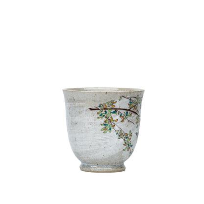 Side view of the Kutani kingfisher mug with leafy decoration near the rim.