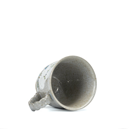 Kutani kingfisher mug tilted to show its gray glazed interior.