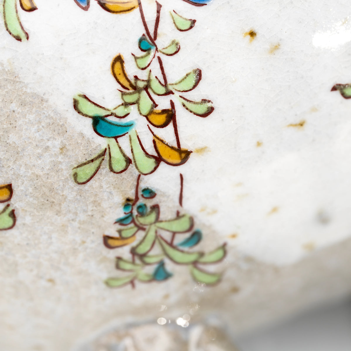 Close-up of green leaves and the rim of the Kutani kingfisher mug.