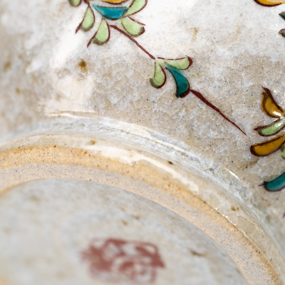 Close-up of the foot ring and painted branches on the Kutani kingfisher mug.