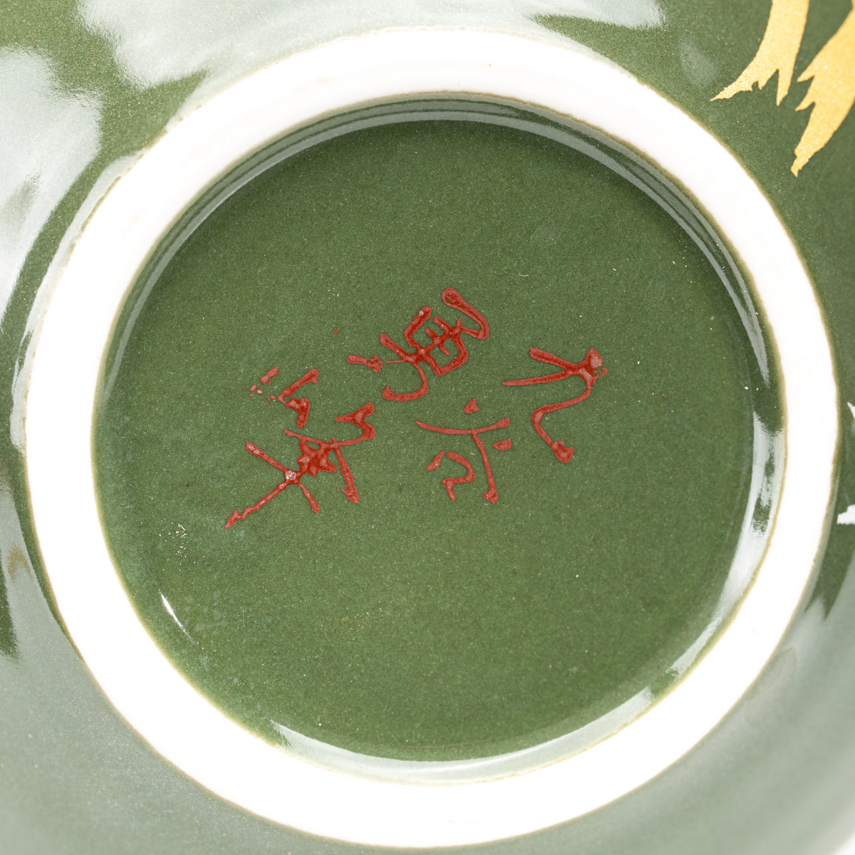 Red maker's mark on the olive-green underside of the vase.
