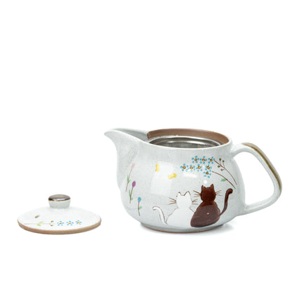 Open cat teapot with its decorated lid placed beside it.