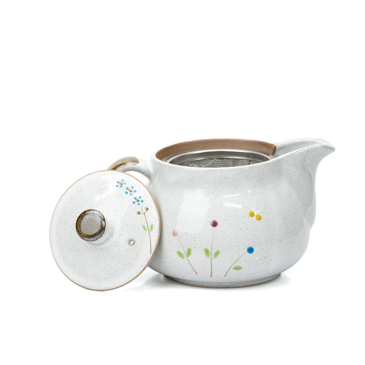 Open flower-painted side of the cat teapot with lid leaning beside it.