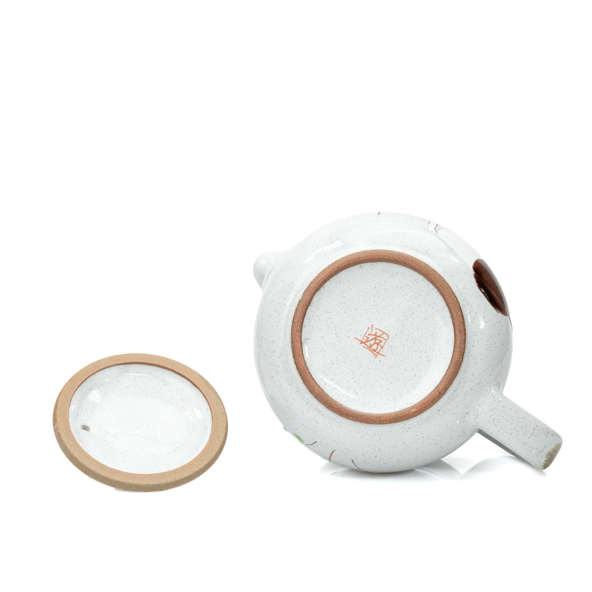 Recessed underside and maker's mark of the teapot beside its lid.