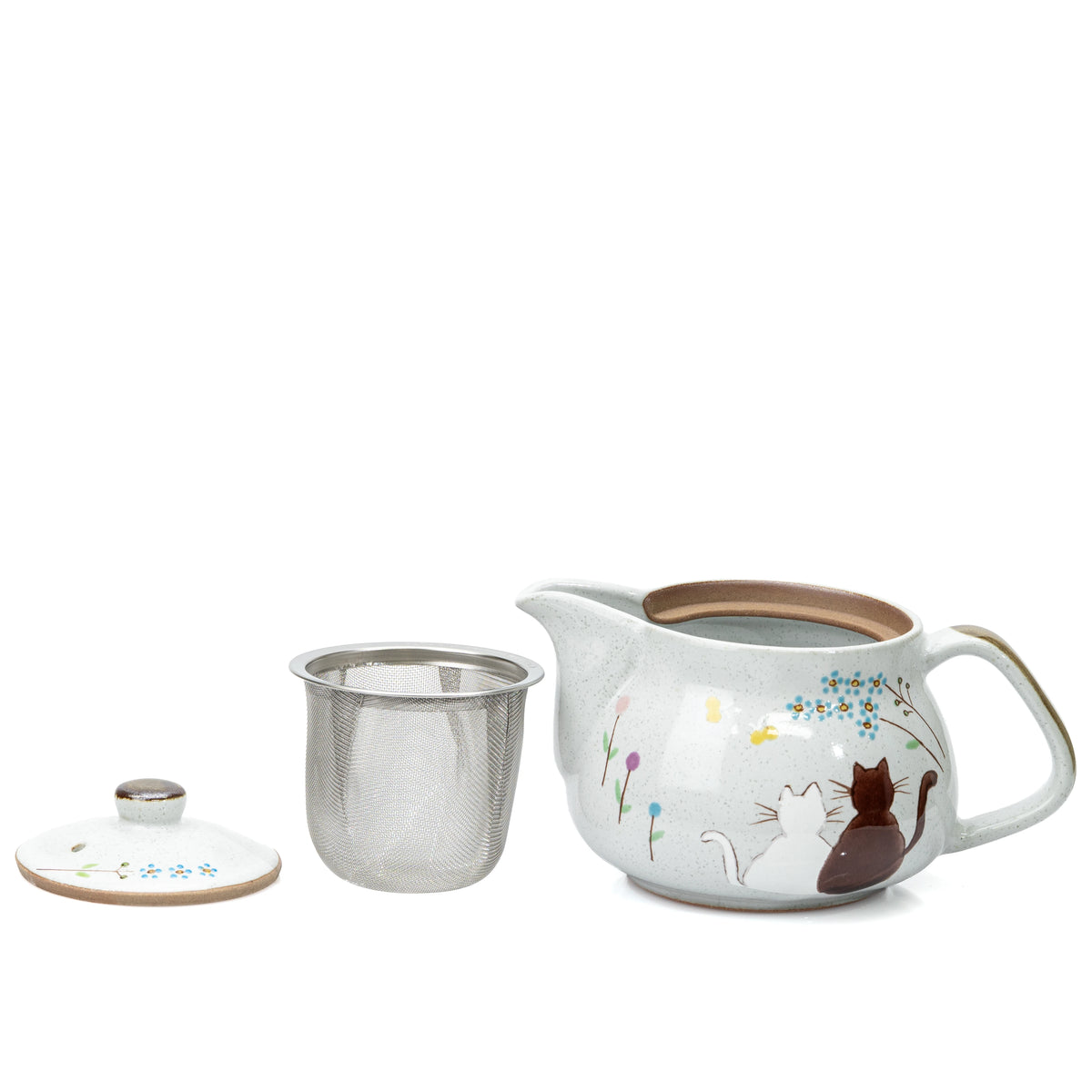 Cat teapot with metal strainer and lid removed and placed beside it.