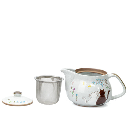 Cat teapot with metal strainer and lid removed and placed beside it.