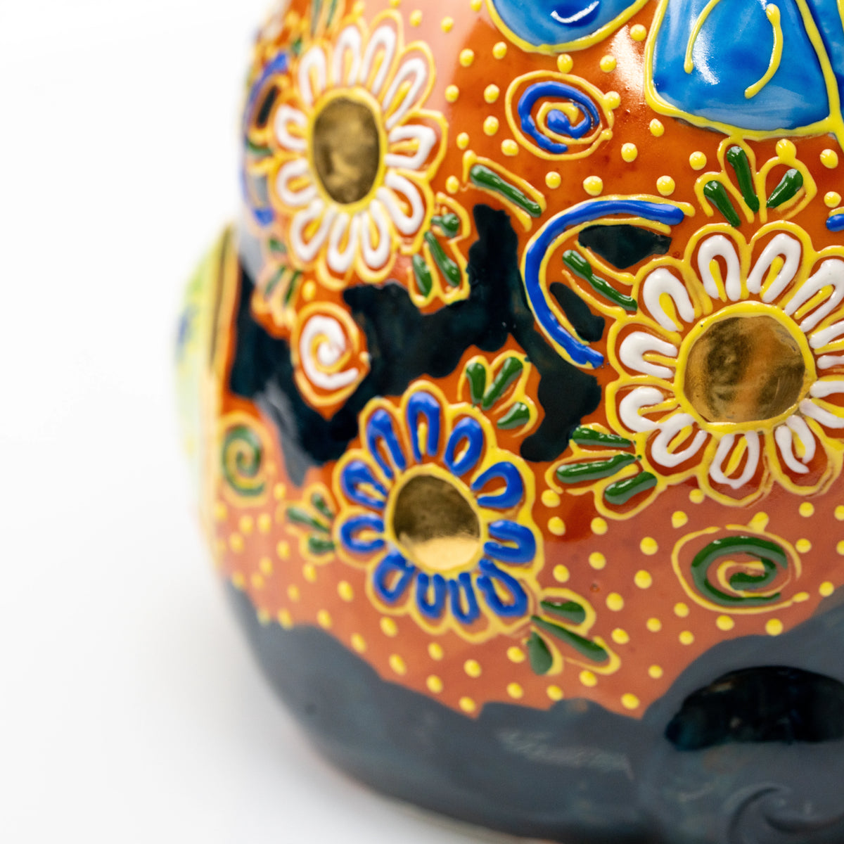Close-up of gold and blue floral patterns on the cat's body.