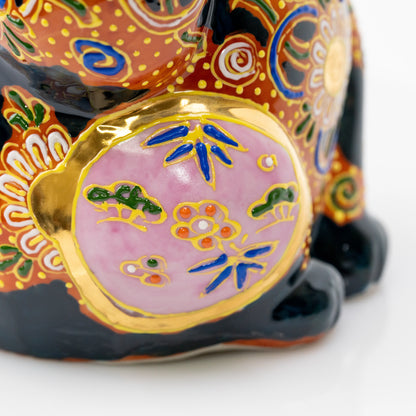 Pink circular panel with small painted motifs on the cat's side.