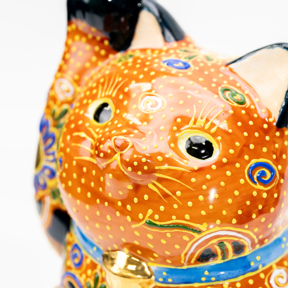 Close-up of the cat's orange face, green eyes and blue collar.