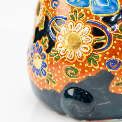 Close-up of raised gold floral details and black tail.