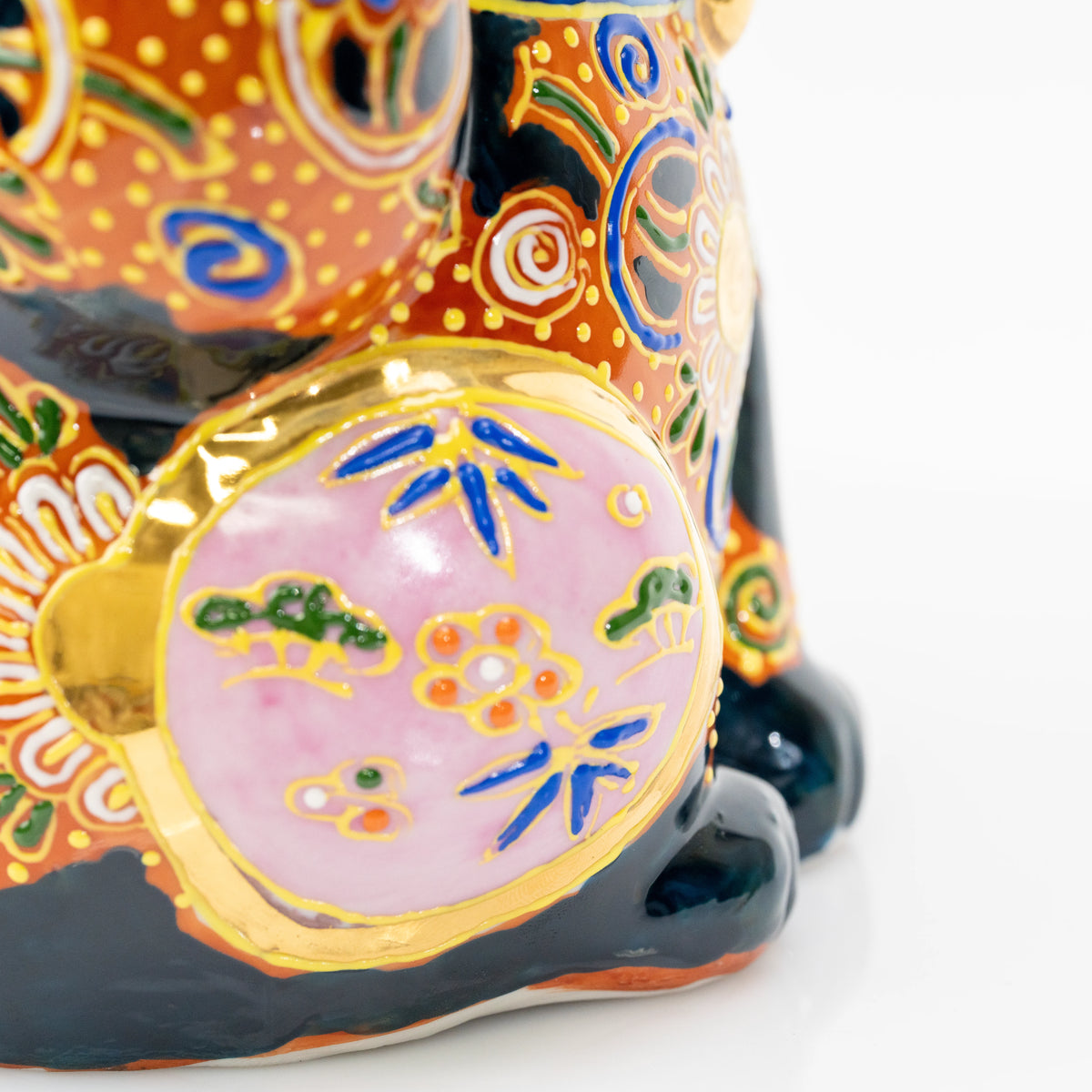 Small painted details inside the cat's pink circular panel.