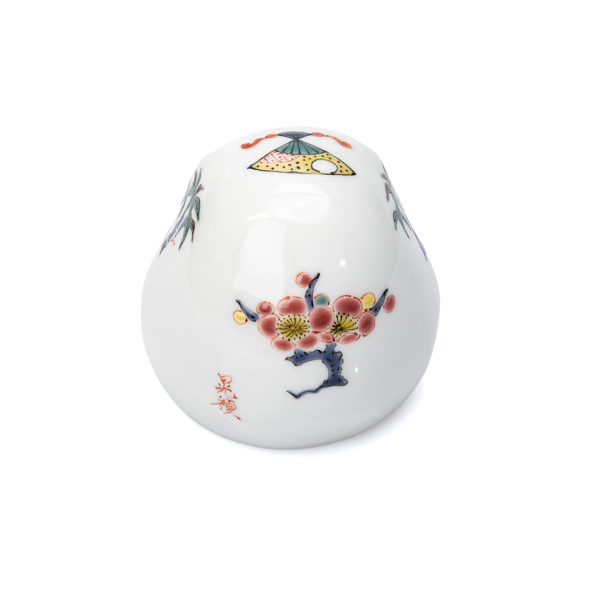 Angled back view of the white daruma and its flowering plum decoration.