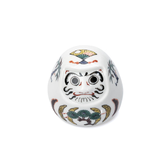 White Kutani daruma with painted pine, bamboo and plum decoration on white.