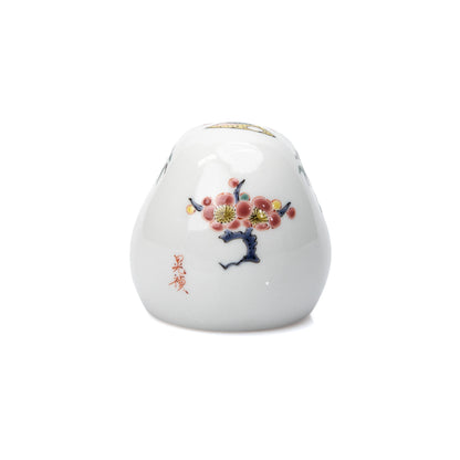Flowering plum and red inscription painted on the daruma's back.