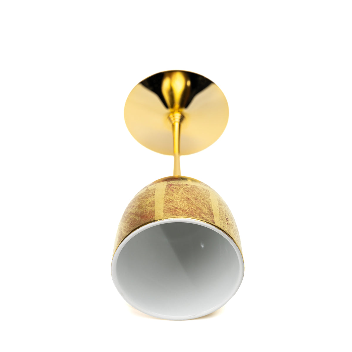 Gold wine cup lying on its side, showing its white bowl interior.
