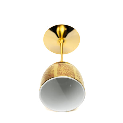 Gold wine cup lying on its side, showing its white bowl interior.