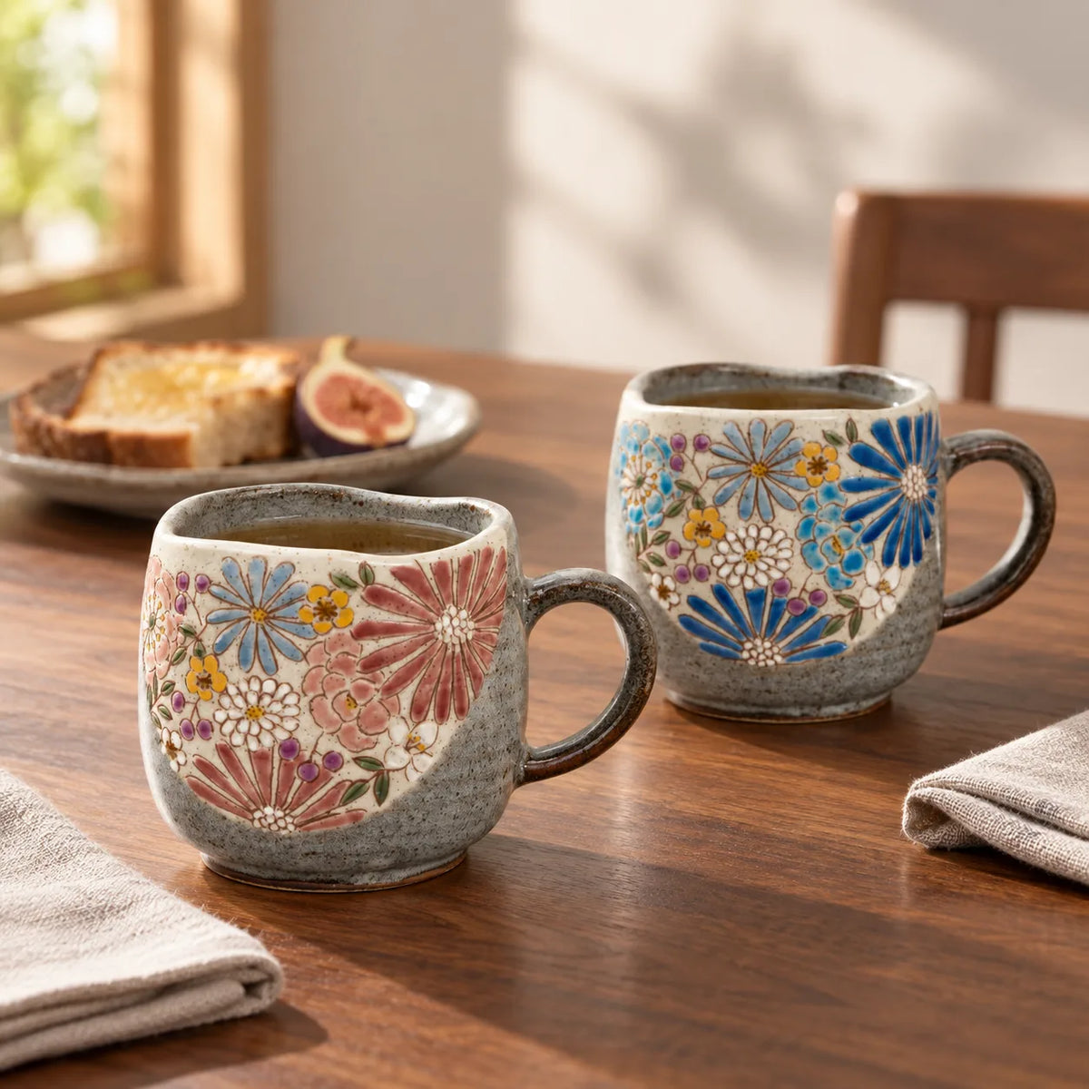 Red and blue Kutani Hana floral mug pair with tea at a quiet breakfast table