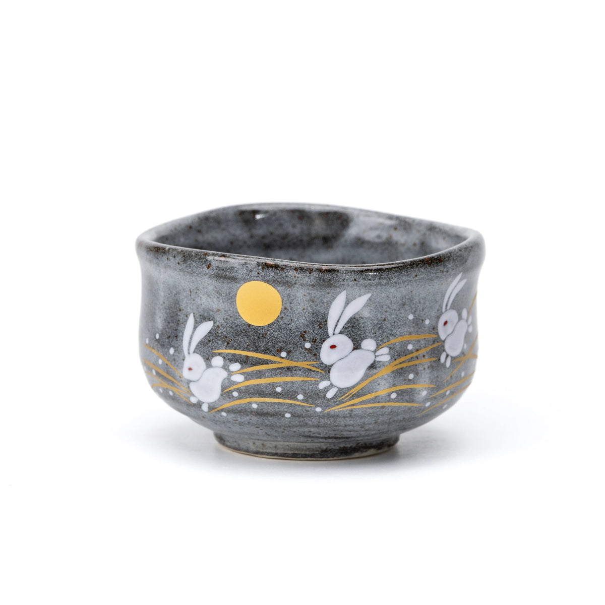 Gray Kutani matcha bowl with white leaping rabbits, golden-colored grasses and a moon on white.