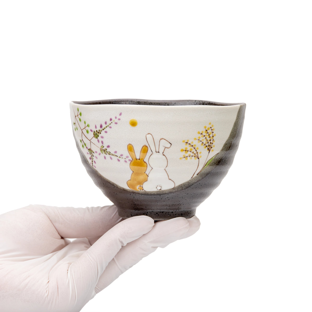 Kutani rabbit bowl held in a gloved hand.