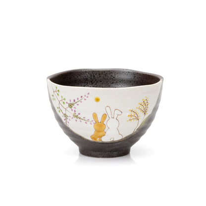 Dark glazed Kutani bowl with two seated rabbits and painted grasses on a cream panel.