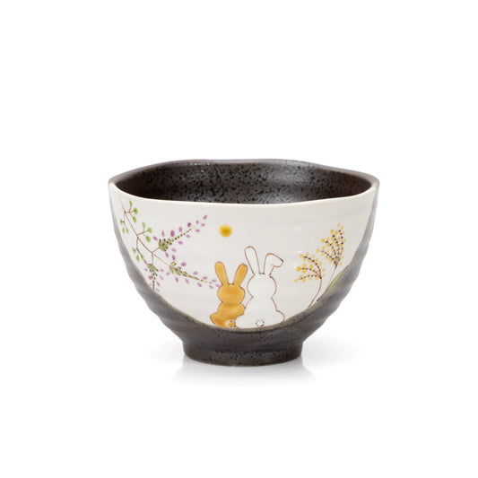 Dark glazed Kutani bowl with two seated rabbits and painted grasses on a cream panel.