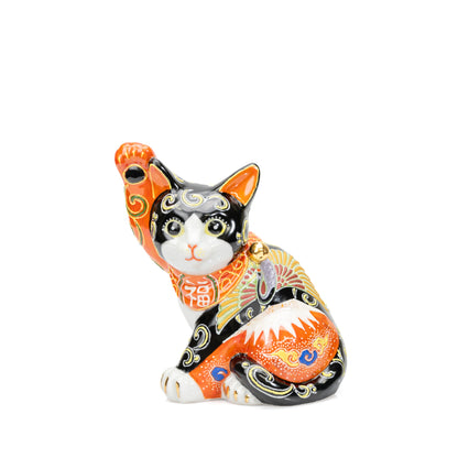 Black and orange Kutani lucky cat with a raised paw, red Mount Fuji and crane decoration on white.