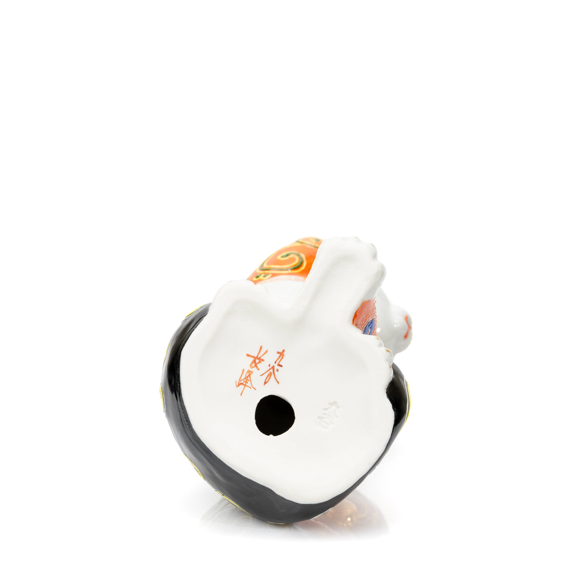 Underside of the lucky cat with a red inscription and round opening.
