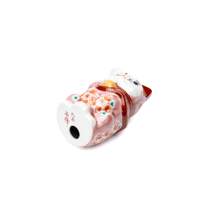Underside of the pink lucky cat with a red inscription and round opening.