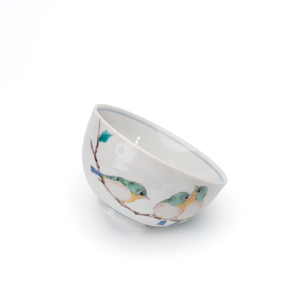 White Kutani rice bowl with painted green and yellow birds, tilted on white.