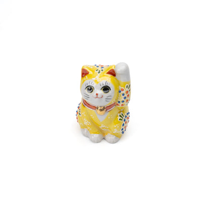 Front angle of the yellow lucky cat with one raised paw.