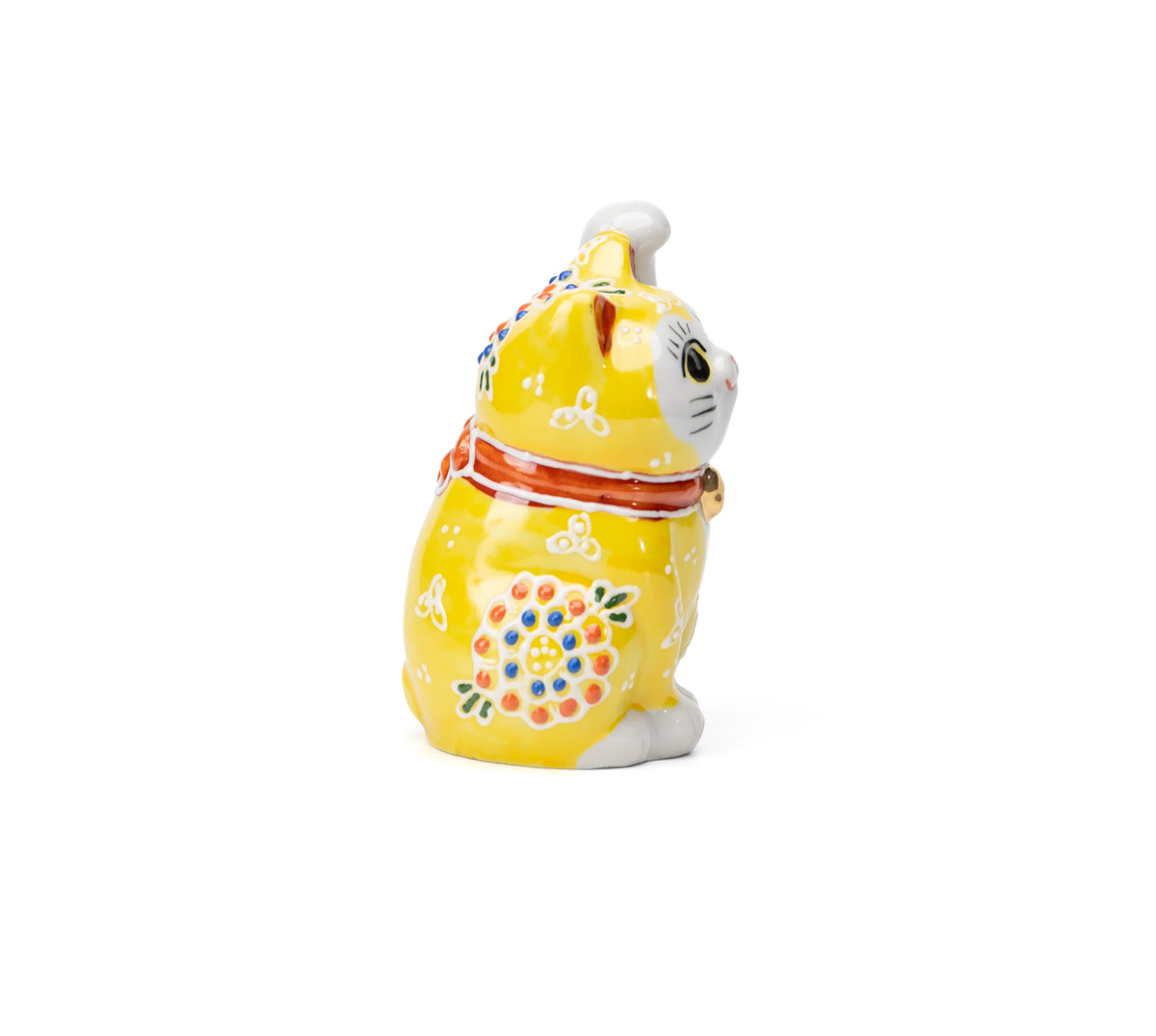 Side view of the yellow cat with a red collar and floral decoration.