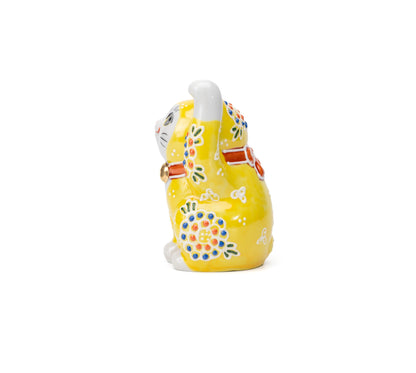 Opposite side of the yellow lucky cat and its raised paw.