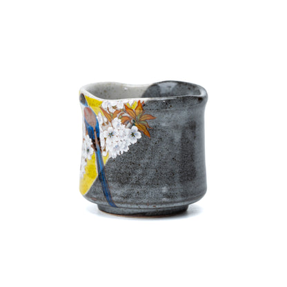 Side view of the yellow bird decoration and textured gray glaze on the yunomi.
