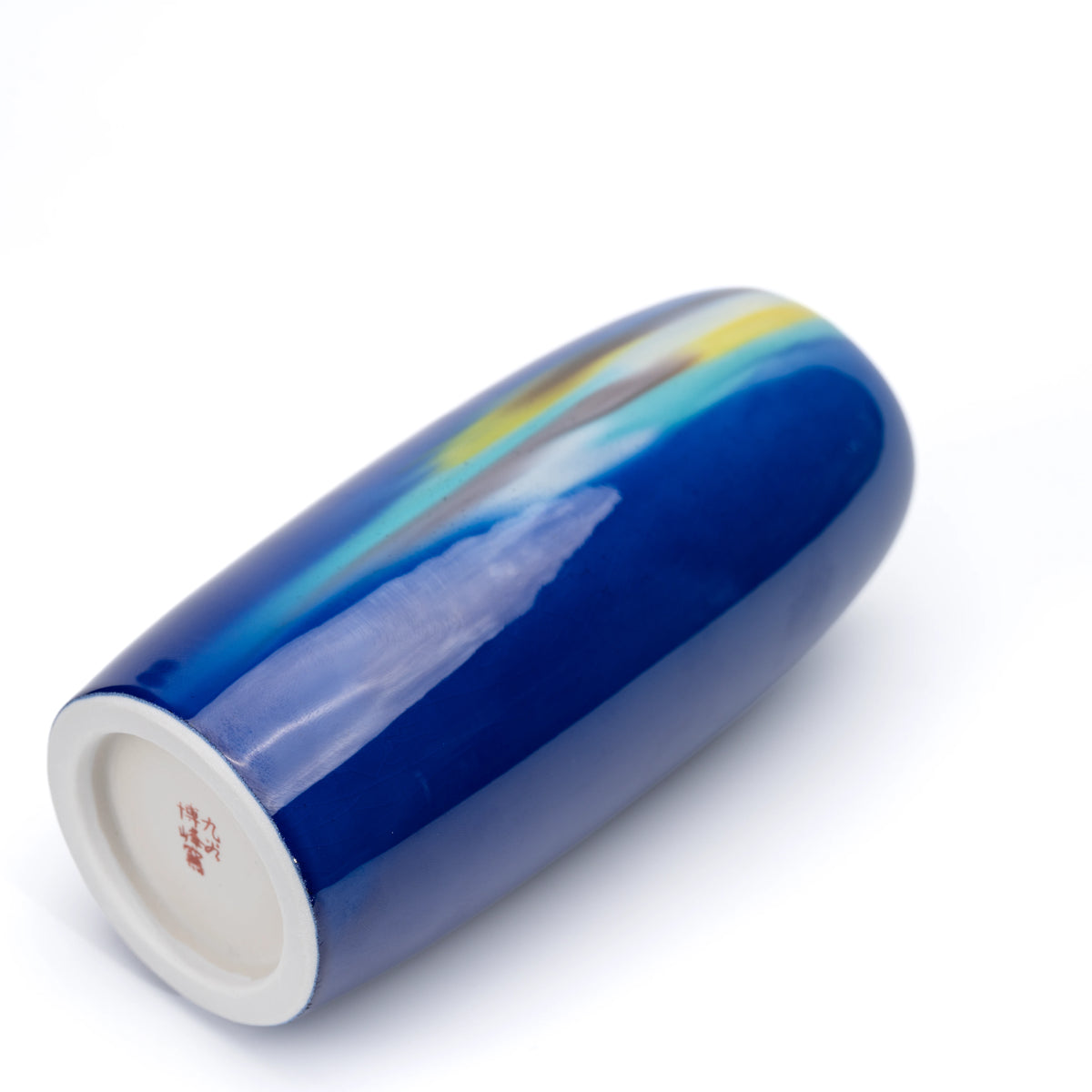 Blue porcelain vase lying on its side, showing the white base and red mark.