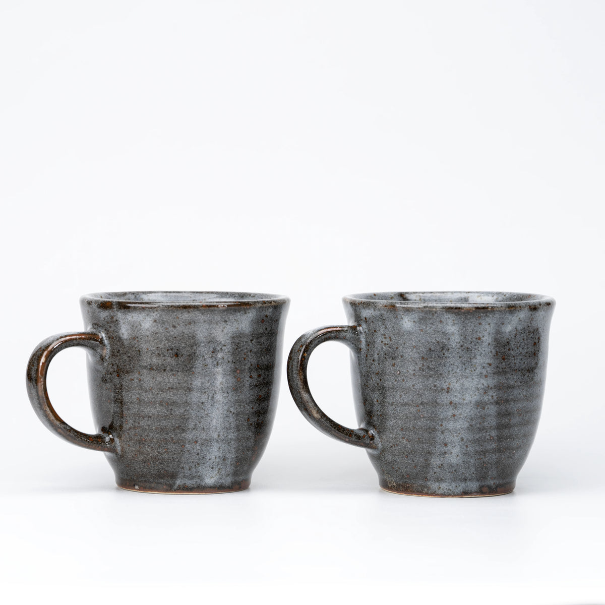 Plain speckled backs and loop handles of the gray mug pair.