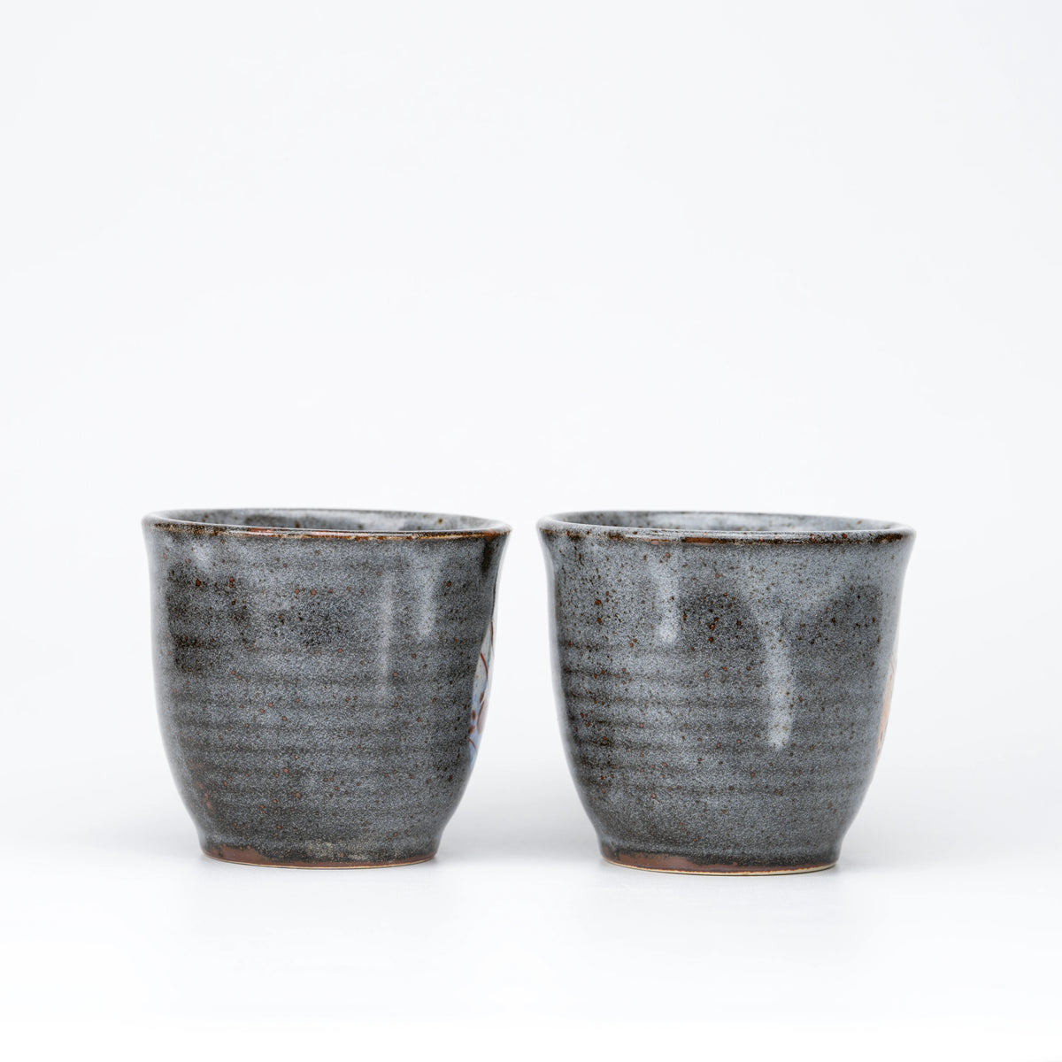 Opposite side view of the two gray speckled mugs.