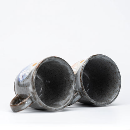Dark speckled interiors of the two mugs.