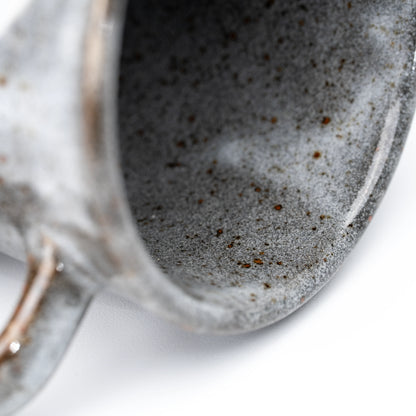 Close-up of the gray speckled interior and rounded rim.
