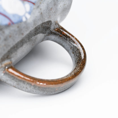 Dark loop handle with a warm brown glazed edge.