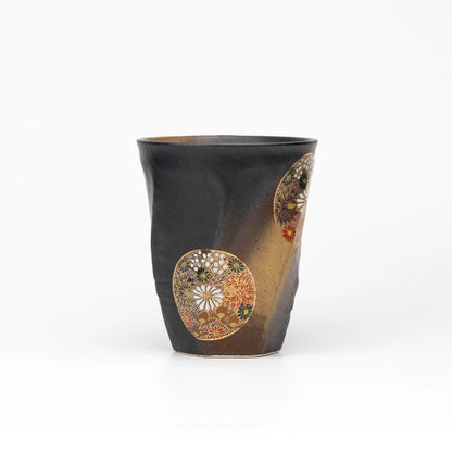 Side view of the black Kutani cup showing floral medallions and gold-colored shading.