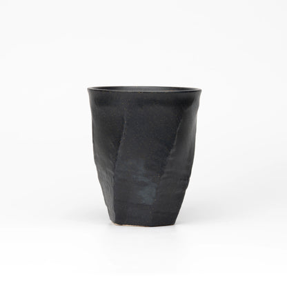 Back view of the black Kutani cup showing its faceted surface.