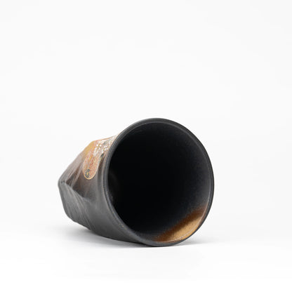 Black Kutani cup tilted to show its dark interior.