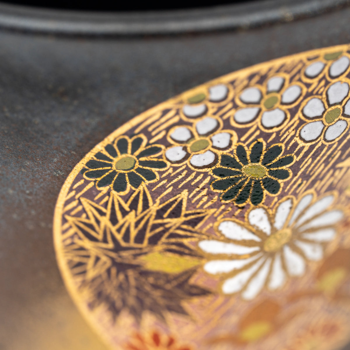 Close-up of gold-colored lines and small flowers on the Kutani cup.