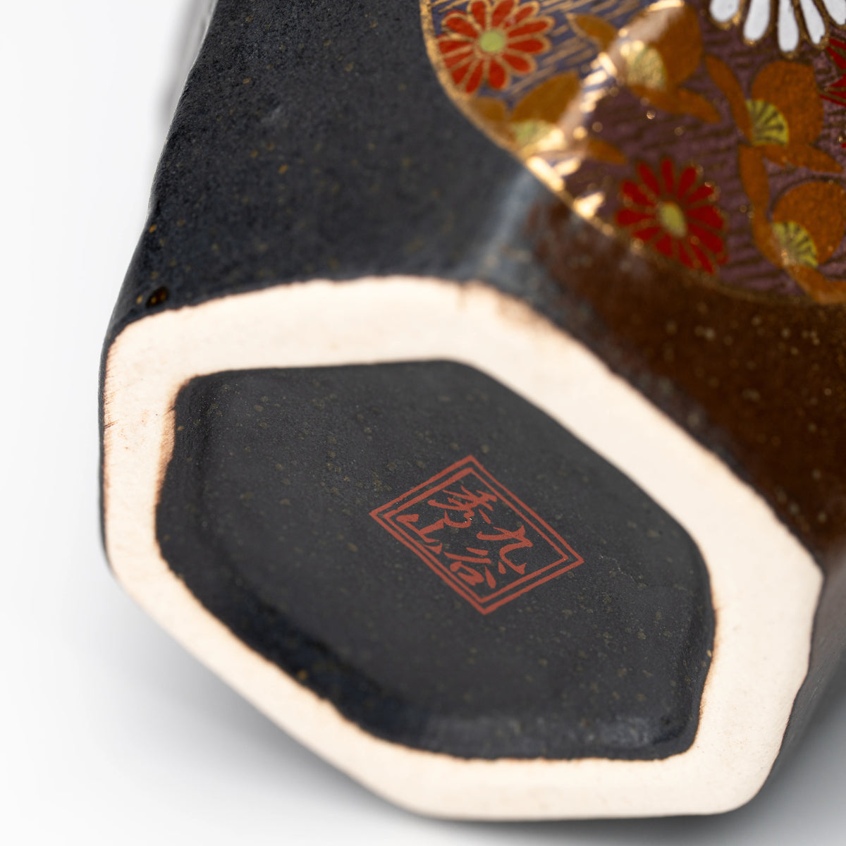 Close-up of the Kutani cup's foot ring and red maker's mark.