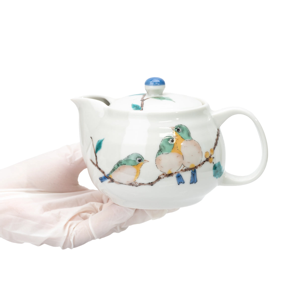 Kutani three-bird teapot held in gloved hands to show scale.