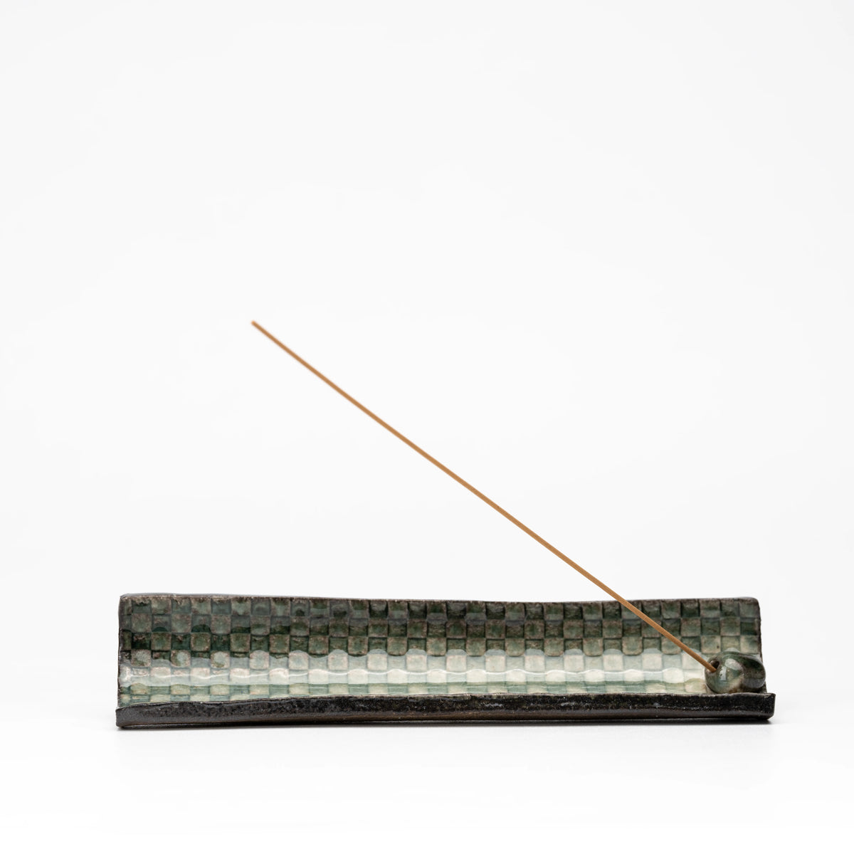Angled view of the green mosaic incense holder and stick insert.