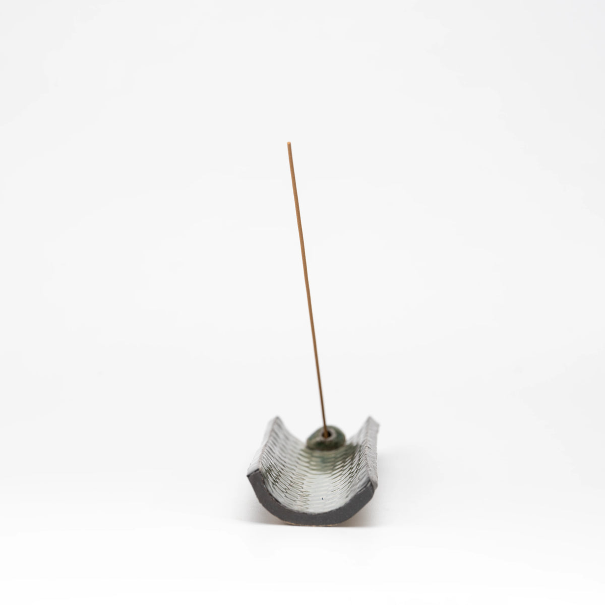 End view of the curved mosaic incense tray with an incense stick.