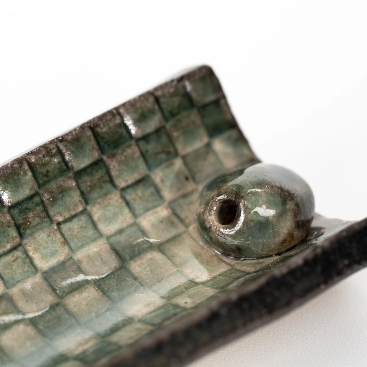 Close-up of the rounded stick insert and green mosaic glaze.